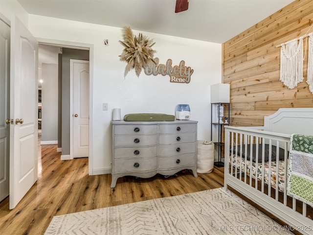 1604 W Los Angeles Cir, Broken Arrow, OK 74011 - bedroom featuring wood finished floors, wooden walls, and ceiling fan
