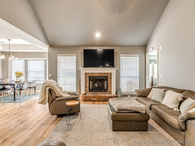 1604 W Los Angeles Cir, Broken Arrow, OK 74011 - living area with lofted ceiling, wood finished floors, a chandelier, a fireplace, and recessed lighting