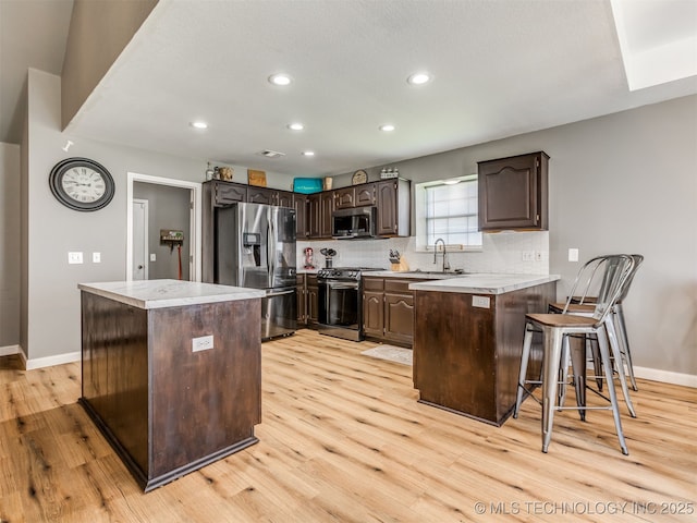 1604 W Los Angeles Cir, Broken Arrow, OK 74011 - kitchen featuring appliances with stainless steel finishes, a peninsula, light wood-type flooring, dark brown cabinets, and recessed lighting