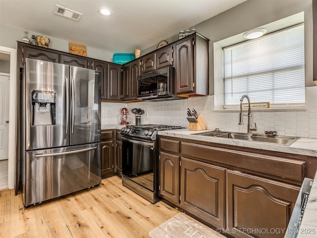 1604 W Los Angeles Cir, Broken Arrow, OK 74011 - kitchen with appliances with stainless steel finishes, light wood finished floors, backsplash, dark brown cabinets, and light countertops