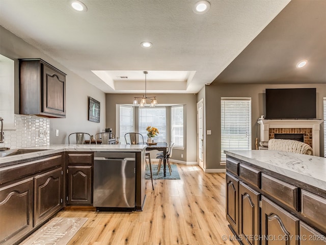 1604 W Los Angeles Cir, Broken Arrow, OK 74011 - kitchen with stainless steel dishwasher, a raised ceiling, light wood-style flooring, dark brown cabinets, and recessed lighting