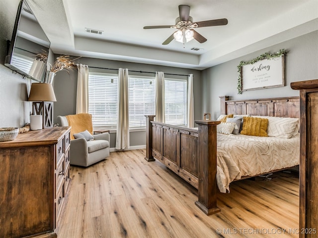 1604 W Los Angeles Cir, Broken Arrow, OK 74011 - bedroom with light wood finished floors, a tray ceiling, and a ceiling fan