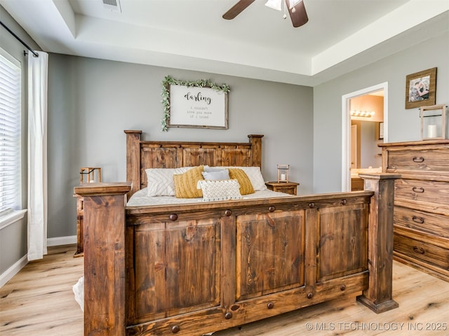 1604 W Los Angeles Cir, Broken Arrow, OK 74011 - bedroom featuring a tray ceiling, light wood finished floors, and ensuite bathroom