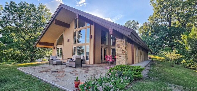 117189 S 4238th Rd, Eufaula, OK 74432 - rear view of property featuring a patio area, stone siding, a lawn, and stucco siding