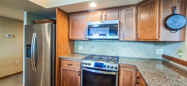 117189 S 4238th Rd, Eufaula, OK 74432 - kitchen featuring appliances with stainless steel finishes, light stone countertops, decorative backsplash, and brown cabinetry