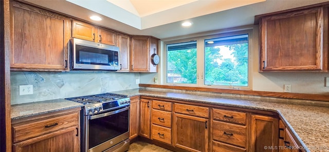 117189 S 4238th Rd, Eufaula, OK 74432 - kitchen with stainless steel appliances, decorative backsplash, recessed lighting, brown cabinets, and vaulted ceiling