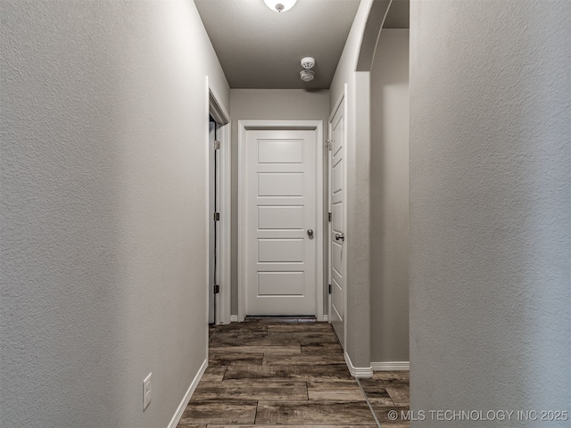 2008 E Union St, Broken Arrow, OK 74011 - hall with dark wood-type flooring, a textured wall, and arched walkways