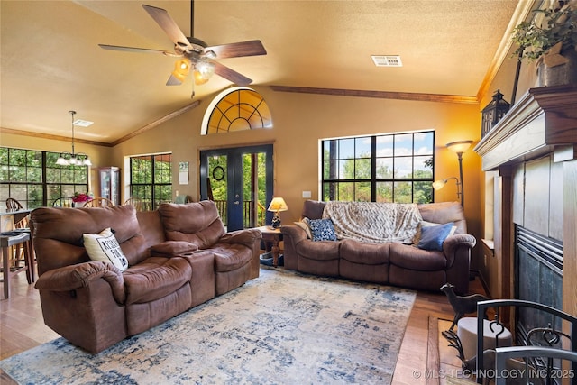 14629 E 233rd St S, Webbers Falls, OK 74470 - living room with a tiled fireplace, lofted ceiling, wood finished floors, ceiling fan, and a chandelier