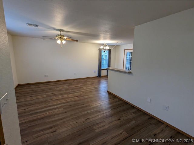1114 W 22nd St, Claremore, OK 74017 - unfurnished room with a chandelier, dark wood-type flooring, and a ceiling fan