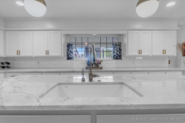 5824 S Louisville Ave, Tulsa, OK 74135 - kitchen featuring backsplash, crown molding, white cabinets, and light stone countertops