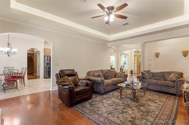 13559 E 463rd Rd, Claremore, OK 74017 - living area featuring arched walkways, a tray ceiling, ceiling fan, light wood-type flooring, and ornamental molding