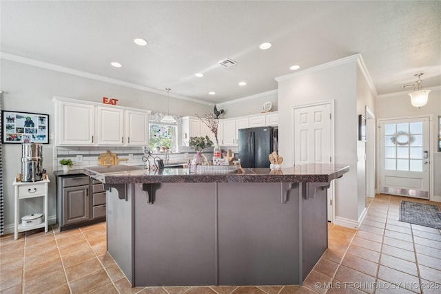 4005 Frontier Rd, Sapulpa, OK 74066 - kitchen featuring freestanding refrigerator, a breakfast bar, tile countertops, ornamental molding, and light tile patterned flooring