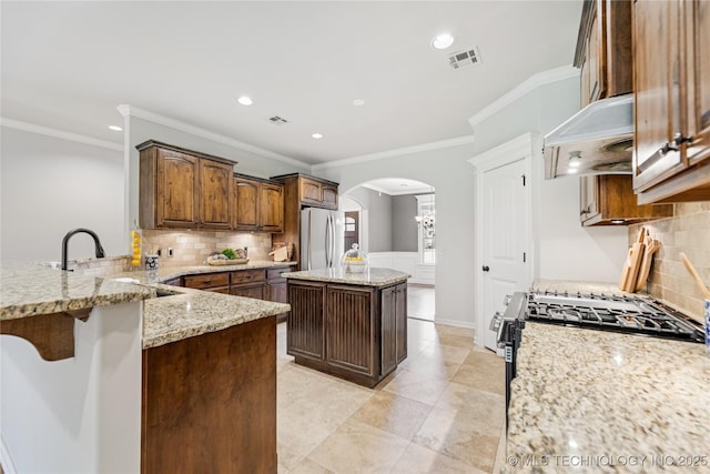 3604 W 109th St S, Jenks, OK 74037 - kitchen featuring premium range hood, freestanding refrigerator, arched walkways, backsplash, and ornamental molding