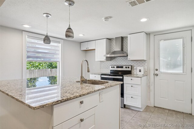 241 S Richmond Ave, Tulsa, OK 74112 - kitchen with wall chimney range hood, stainless steel electric range, light tile patterned floors, white cabinetry, and light stone counters
