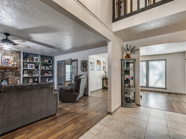 6708 S 5th St, Broken Arrow, OK 74011 - living room featuring a ceiling fan, wood finished floors, a textured ceiling, and a fireplace
