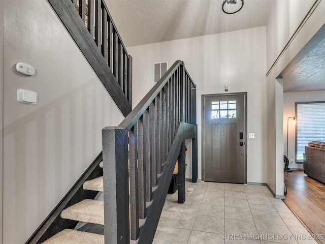 6708 S 5th St, Broken Arrow, OK 74011 - entryway with stairway, a textured ceiling, and a towering ceiling