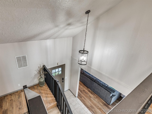 6708 S 5th St, Broken Arrow, OK 74011 - stairs with a textured ceiling, a chandelier, vaulted ceiling, and tile patterned floors