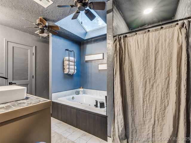 6708 S 5th St, Broken Arrow, OK 74011 - bathroom featuring a textured wall, ceiling fan, a bath, vanity, and a skylight