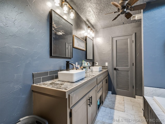 6708 S 5th St, Broken Arrow, OK 74011 - bathroom with ceiling fan, double vanity, marble look tiles, a textured wall, and a bath