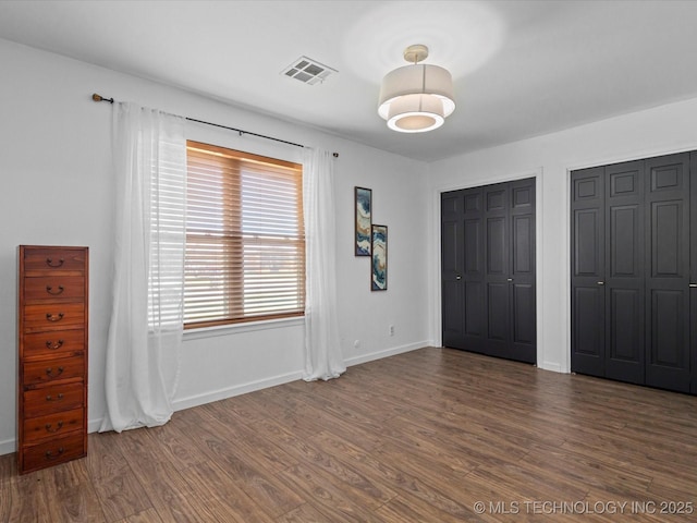 6725 Dorsett Dr, Bartlesville, OK 74006 - unfurnished bedroom featuring wood finished floors and two closets
