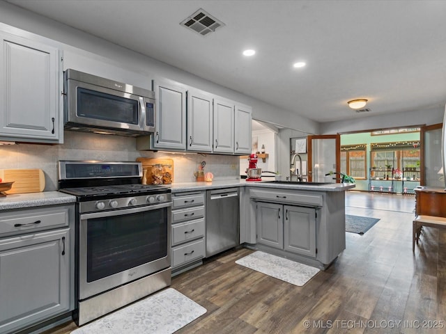 6725 Dorsett Dr, Bartlesville, OK 74006 - kitchen with appliances with stainless steel finishes, gray cabinetry, a peninsula, recessed lighting, and backsplash