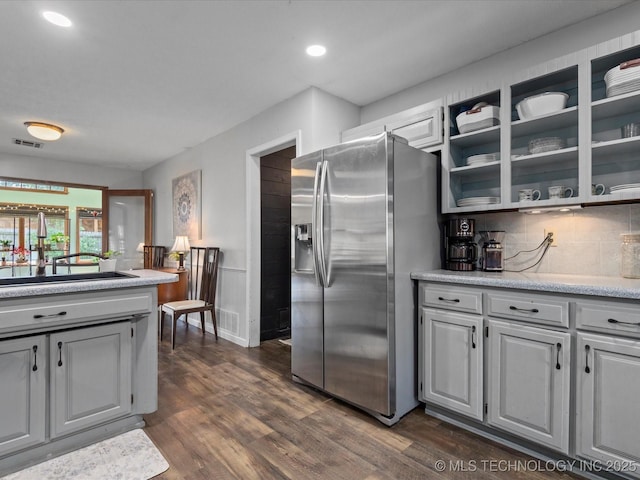 6725 Dorsett Dr, Bartlesville, OK 74006 - kitchen with stainless steel fridge with ice dispenser, light countertops, dark wood-type flooring, tasteful backsplash, and recessed lighting