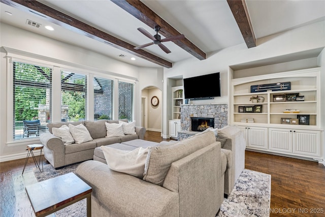11029 S Kennedy St, Jenks, OK 74037 - living room with arched walkways, a ceiling fan, dark wood finished floors, a fireplace, and beamed ceiling