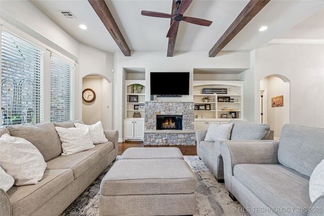 11029 S Kennedy St, Jenks, OK 74037 - living room featuring arched walkways, ceiling fan, wood finished floors, beam ceiling, and a stone fireplace