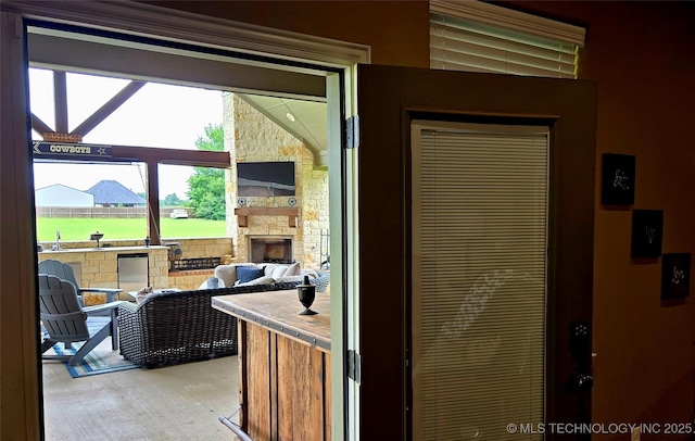 6865 Wilson St, Durant, OK 74701 - doorway to outside with an outdoor stone fireplace and light wood-style floors
