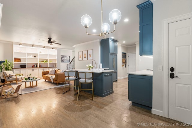 12511 S 18th Cir E, Jenks, OK 74037 - kitchen featuring blue cabinetry, ornamental molding, ceiling fan, a breakfast bar, and light countertops