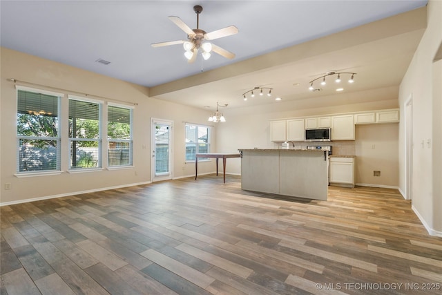 12522 S Cedar Ave, Jenks, OK 74037 - kitchen with stainless steel microwave, a ceiling fan, light wood finished floors, and white cabinetry
