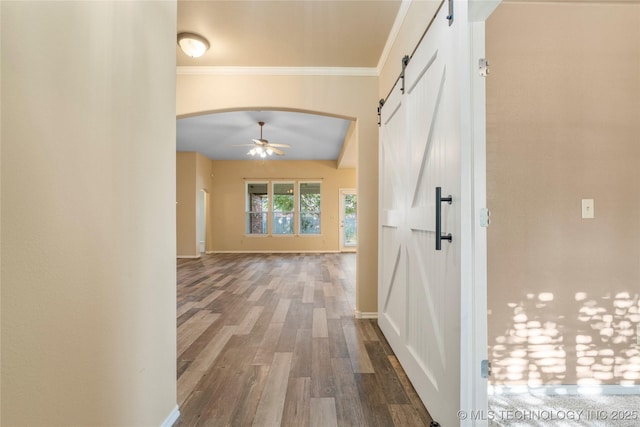 12522 S Cedar Ave, Jenks, OK 74037 - hallway featuring a barn door, wood finished floors, arched walkways, and ornamental molding