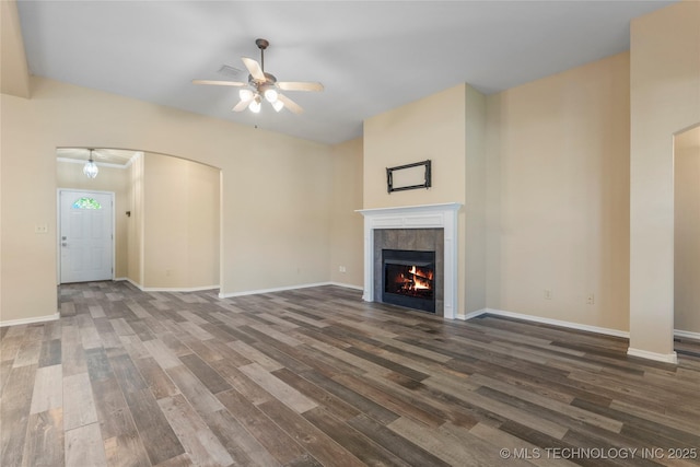 12522 S Cedar Ave, Jenks, OK 74037 - unfurnished living room with ceiling fan, wood finished floors, a tile fireplace, and arched walkways