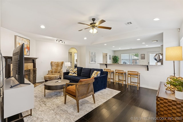 2610 E 5th Pl, Tulsa, OK 74104 - living room featuring ceiling fan, dark wood-style flooring, arched walkways, recessed lighting, and a tile fireplace