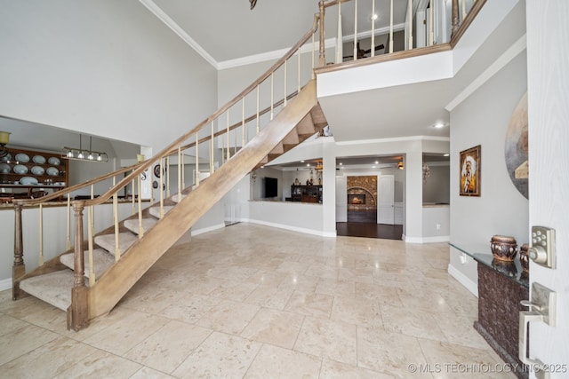 8120 E 112th St, Owasso, OK 74055 - stairs with a high ceiling, crown molding, and a lit fireplace