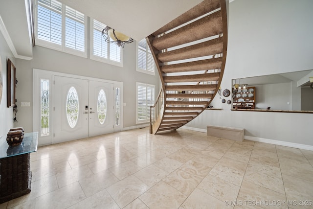 8120 E 112th St, Owasso, OK 74055 - tiled entrance foyer with stairs, a high ceiling, and a chandelier