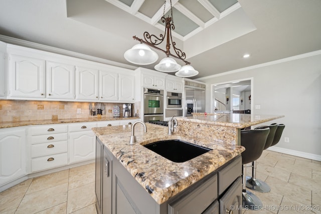 8120 E 112th St, Owasso, OK 74055 - kitchen with appliances with stainless steel finishes, a center island with sink, crown molding, decorative backsplash, and hanging light fixtures