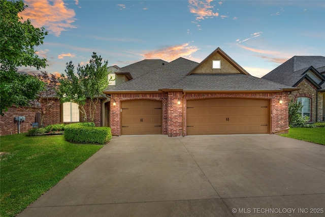 3712 W 107th Ct, Jenks, OK 74037 - french country home with an attached garage, concrete driveway, a front lawn, and roof with shingles