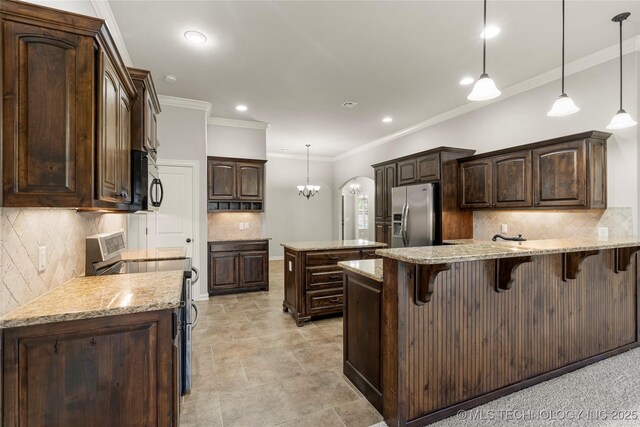 3712 W 107th Ct, Jenks, OK 74037 - kitchen featuring appliances with stainless steel finishes, dark brown cabinets, a peninsula, decorative backsplash, and crown molding