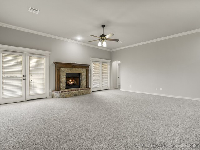 3712 W 107th Ct, Jenks, OK 74037 - unfurnished living room with crown molding, a ceiling fan, arched walkways, carpet, and a warm lit fireplace