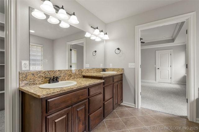 3712 W 107th Ct, Jenks, OK 74037 - bathroom featuring double vanity, tile patterned floors, a walk in closet, and a raised ceiling