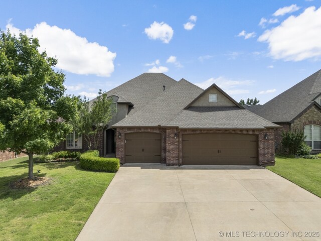3712 W 107th Ct, Jenks, OK 74037 - french country inspired facade featuring an attached garage, roof with shingles, a front lawn, driveway, and brick siding