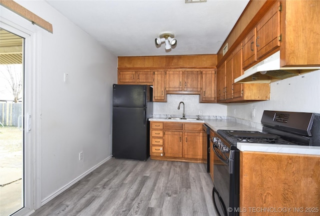 20529 E 4th St, Tulsa, OK 74108 - kitchen featuring black appliances, light countertops, light wood-type flooring, and under cabinet range hood