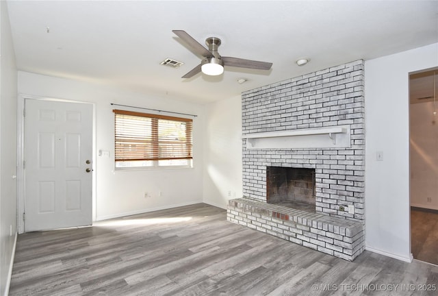 20529 E 4th St, Tulsa, OK 74108 - unfurnished living room featuring a ceiling fan, wood finished floors, and a brick fireplace