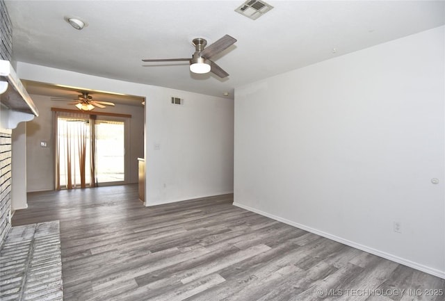 20529 E 4th St, Tulsa, OK 74108 - empty room with a ceiling fan, wood finished floors, and a brick fireplace