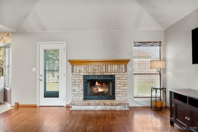 3220 N 3rd Pl, Broken Arrow, OK 74012 - living area with vaulted ceiling, wood finished floors, healthy amount of natural light, and a brick fireplace