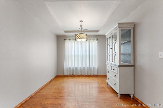 3220 N 3rd Pl, Broken Arrow, OK 74012 - unfurnished dining area featuring light wood-style floors and a raised ceiling