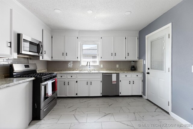 10942 E 4th Pl N, Tulsa, OK 74128 - kitchen featuring stainless steel appliances, light marble finish floors, white cabinetry, a textured ceiling, and recessed lighting