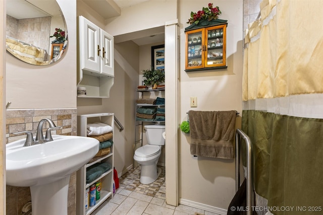 3811 Broadway Ct, Ada, OK 74820 - bathroom with toilet and tasteful backsplash