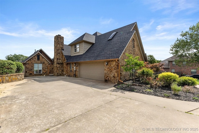 1505 Augusta, Ada, OK 74820 - view of front facade with driveway, stone siding, a garage, a chimney, and roof with shingles